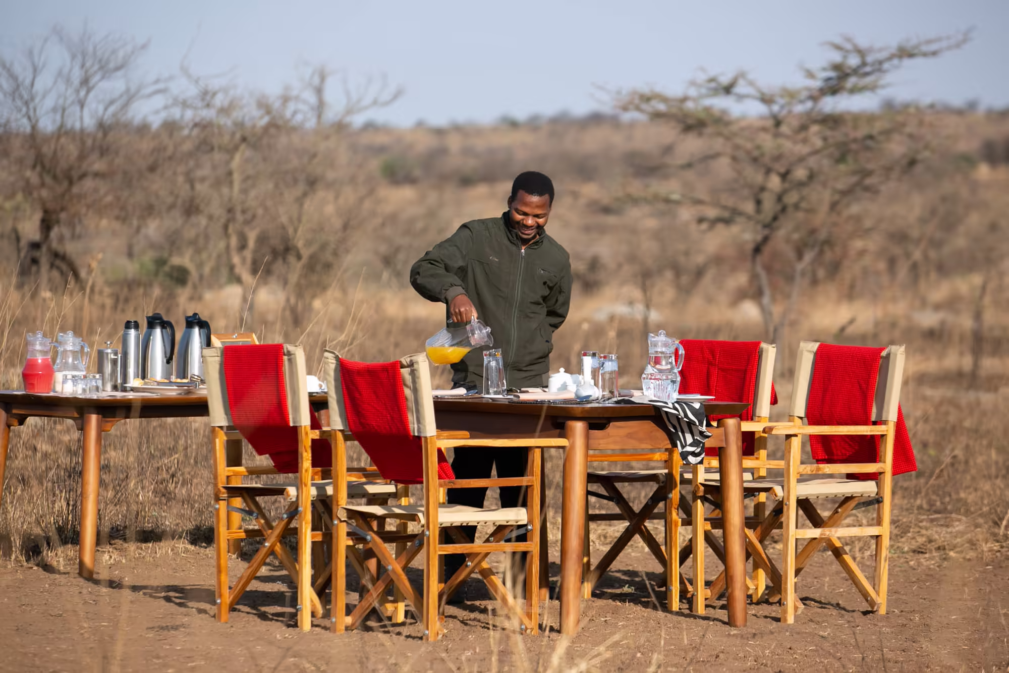 Guide setting a bush breakfast table in the savanna