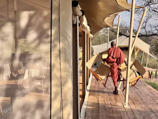 Maasai host walking along the tent walkway