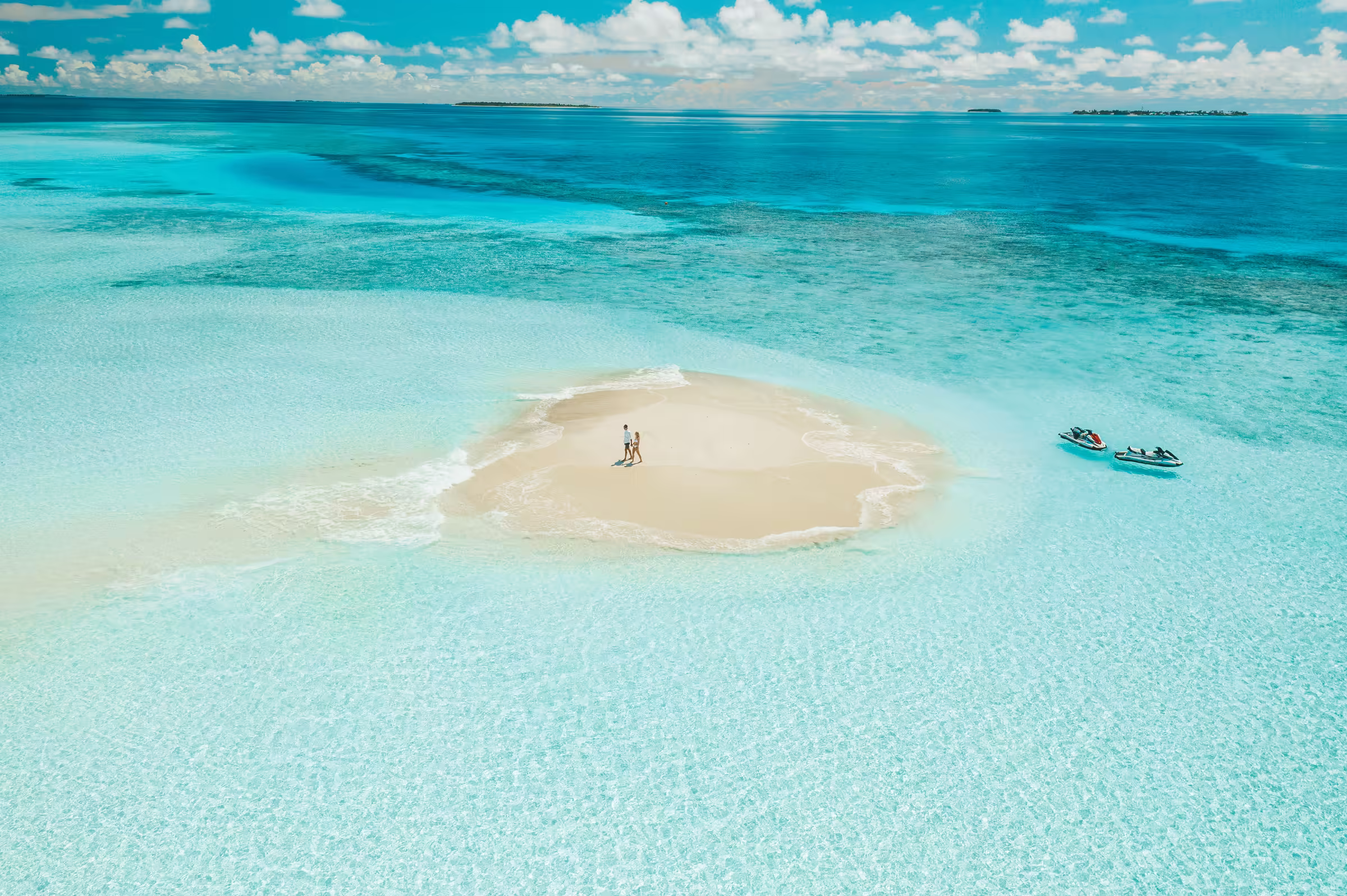 A couple standing on a small sandy island
