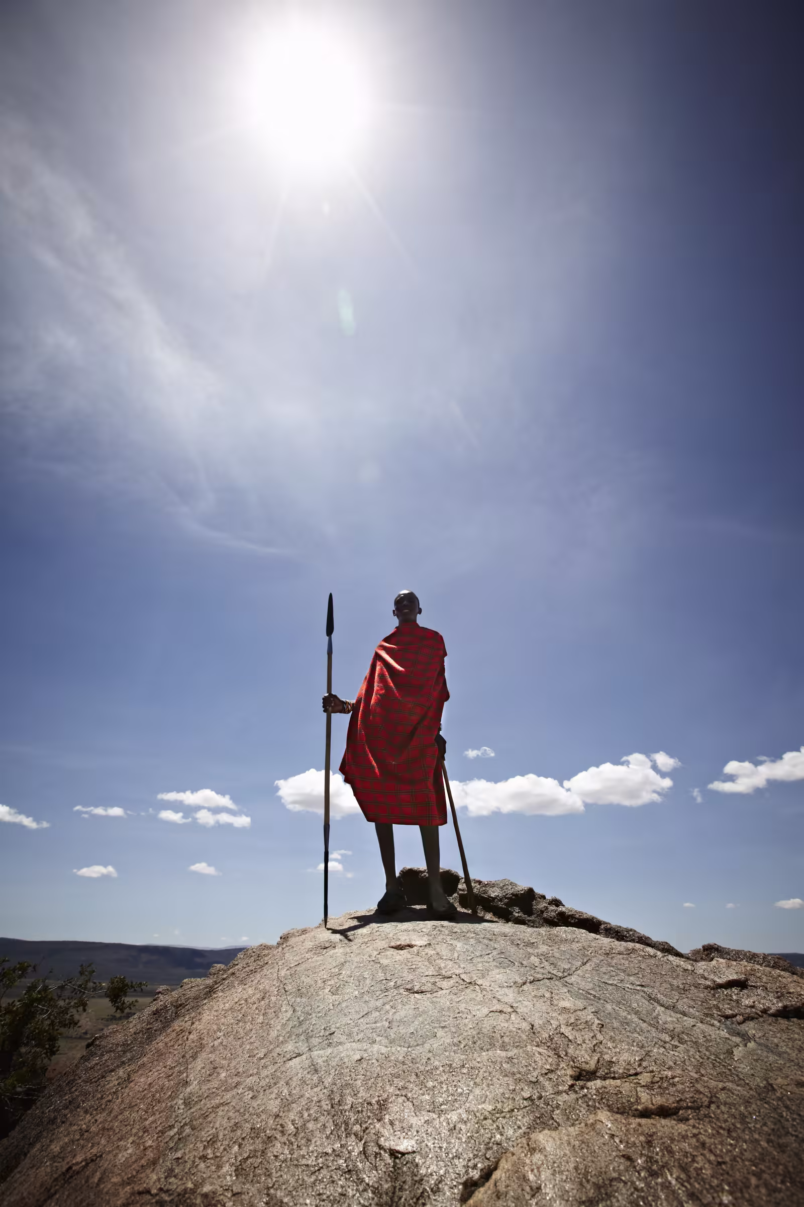 Maasai man standing on top of rock