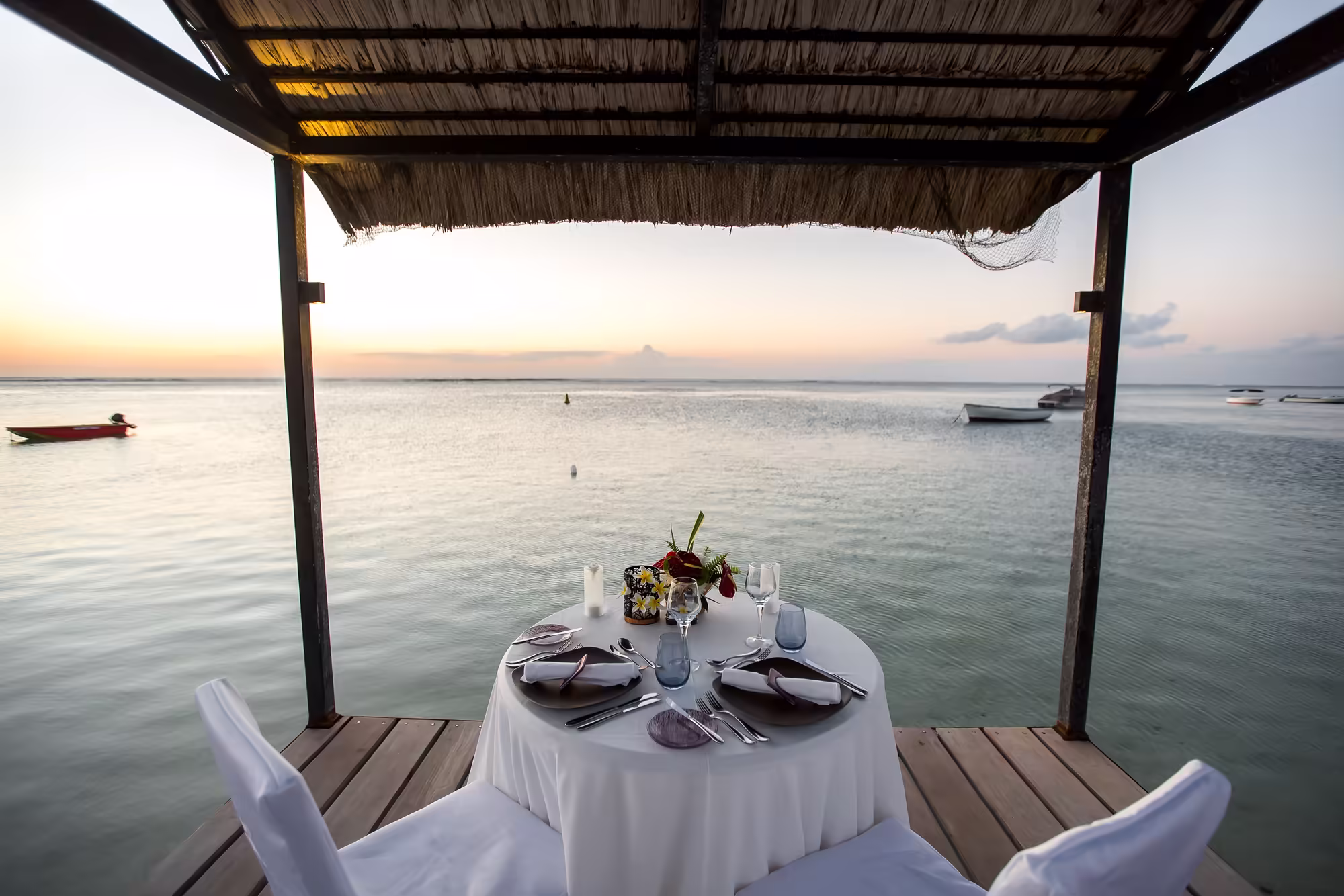 Romantic dinner setting on the beach at sunset